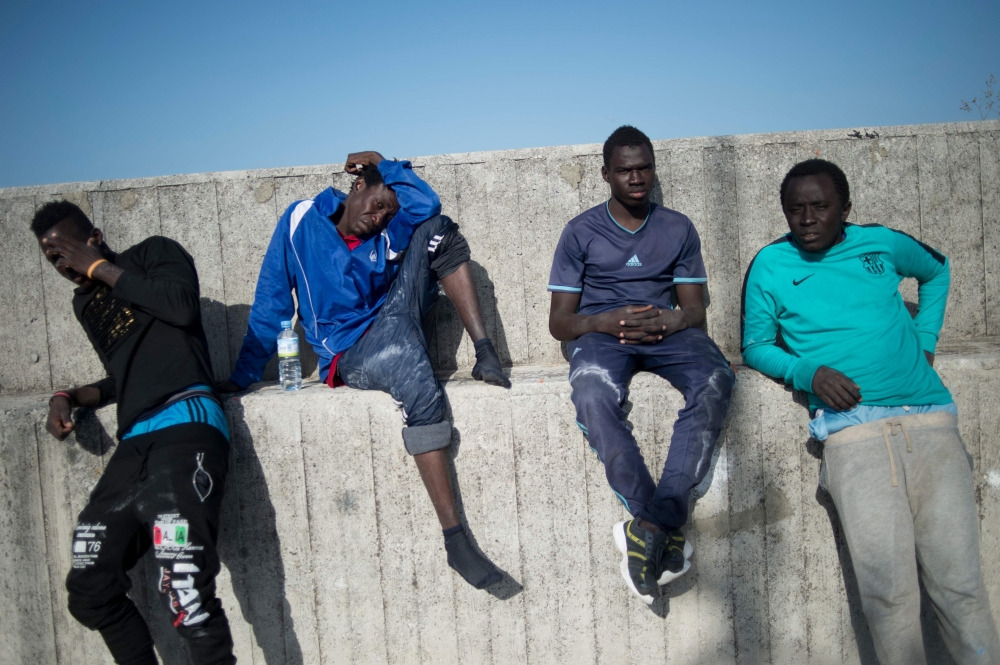 Migrants stand after arriving aboard a coast guard boat at Algecira’s harbor on Saturday, after an inflatable boat carrying 9 migrants was rescued by the Spanish coast guard off the Spanish coast. — AFP
