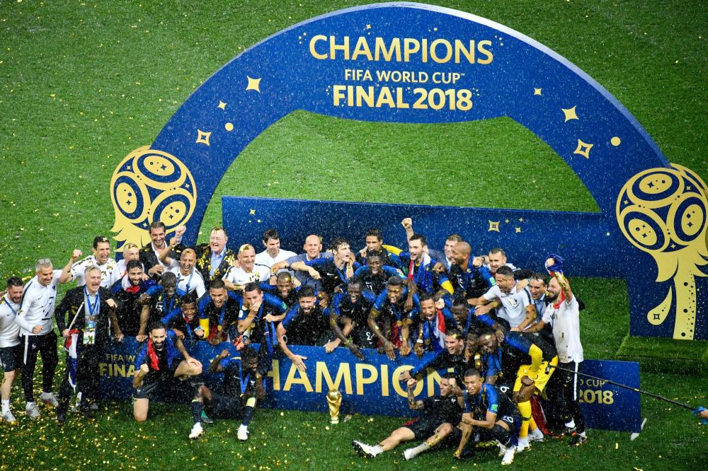 France's players pose with the trophy as they celebrate after winning the Russia 2018 World Cup final against Croatia at the Luzhniki Stadium in Moscow Sunday. — AFP 