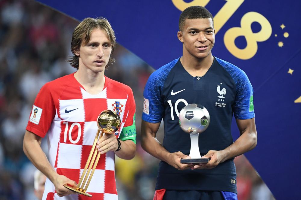 France's forward Kylian Mbappe (R) poses with the FIFA Young Player award beside Croatia's midfielder Luka Modric holding the adidas Golden Ball prize (best player) during the trophy ceremony at the end of the Russia 2018 World Cup final at the Luzhniki Stadium in Moscow Sunday. — AFP 