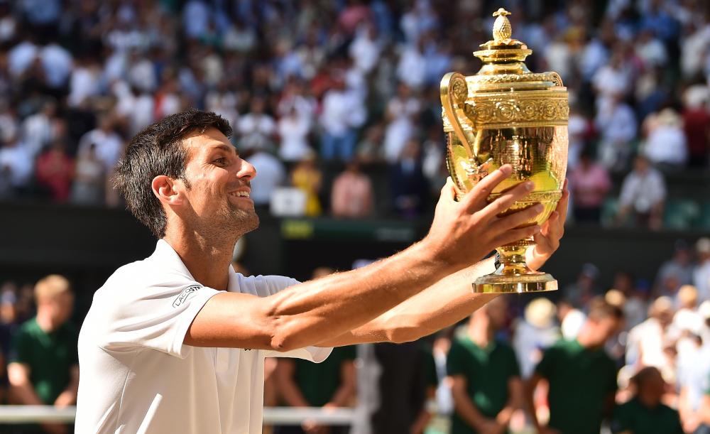 Serbia's Novak Djokovic holds the winner’s trophy after beating South Africa's Kevin Anderson in the men's final at the 2018 Wimbledon Championships Sunday. — AFP 