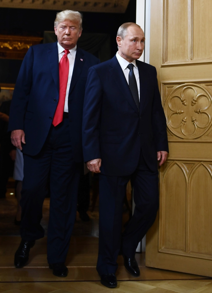 US President Donald Trump (left) and Russia's President Vladimir Putin wait ahead of a meeting in Helsinki, Monday.  — AFP
