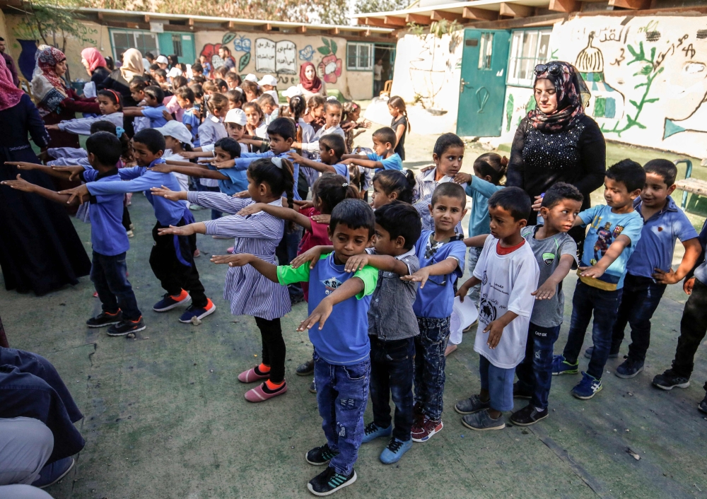 Palestinian children queue up before the early start of classes at a school in the Bedouin village of Khan Al-Ahmar in the occupied West Bank, during the Palestinian Prime Minister's visit to the village this week. — AFP