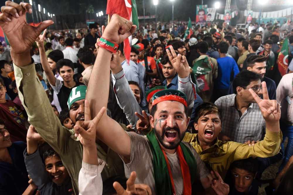 Supporters of Pakistani cricket star-turned-politician and head of the Pakistan Tehreek-e-Insaf (PTI) Imran Khan, unseen gather at his political campaign rally for the upcoming general election in Lahore on Wednesday. — AFP