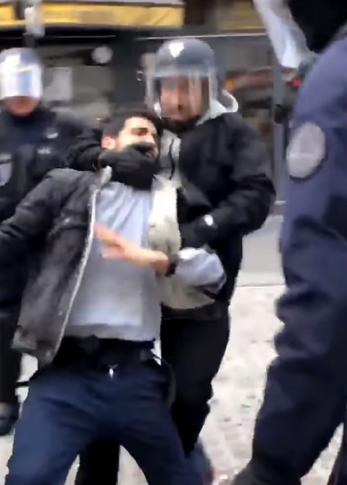 In this video grab taken on July 19, 2018 from footage filmed on May 1, 2018 shows a man identified as Elysee Chief Security Officer Alexandre Benalla wearing a police visor as he drags away a demonstrator during May 1 protests in Paris. — AFP