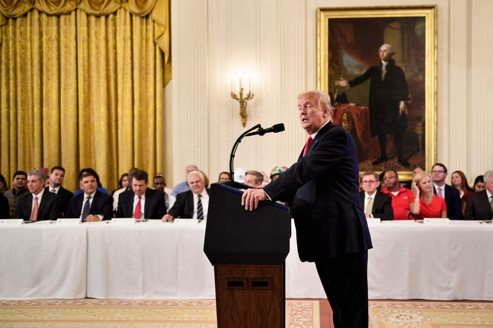 US President Donald Trump, beneath a portrait of first US president George Washington, addresses the Pledge to America’s Workers event at the White House in Washington on Thursday. — AFP