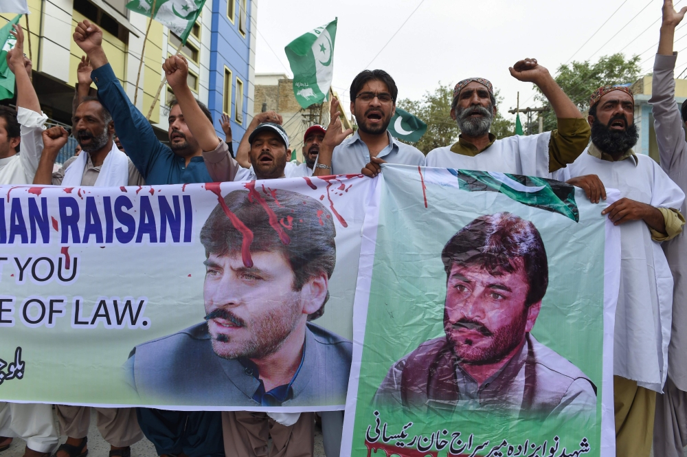 Pakistani activists of Balochistan Awami Party (BAP) chant slogans as they hold a banner reading “We will never forget you, it’s a pity there is no rule of law” during a protest in Quetta on Wednesday, following a suicide attack in southwestern Pakistan. — AFP