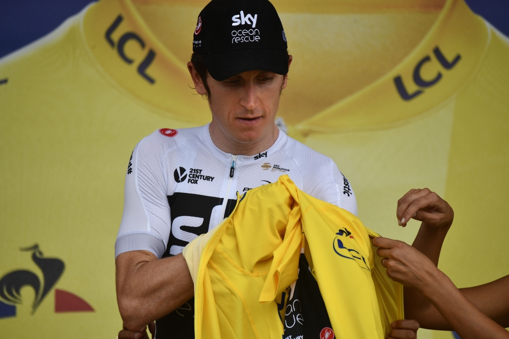 Great Britain's Geraint Thomas puts on the overall leader's yellow jersey on the podium after the 13th stage of the 105th edition of the Tour de France cycling race, between Le Bourg-d'Oisans and Valence, on Friday. — AFP