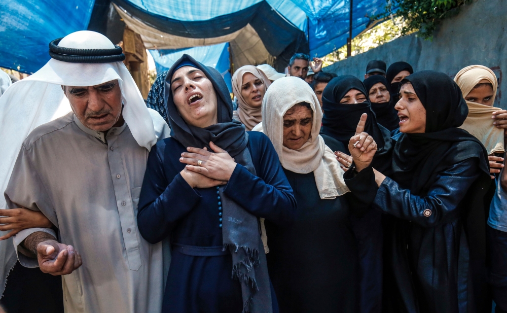 Relatives of killed Hamas member Mohamed Abu Daqa react and mourn during his funeral in Khan Yunis in the southern Gaza Strip on Saturday. — AFP