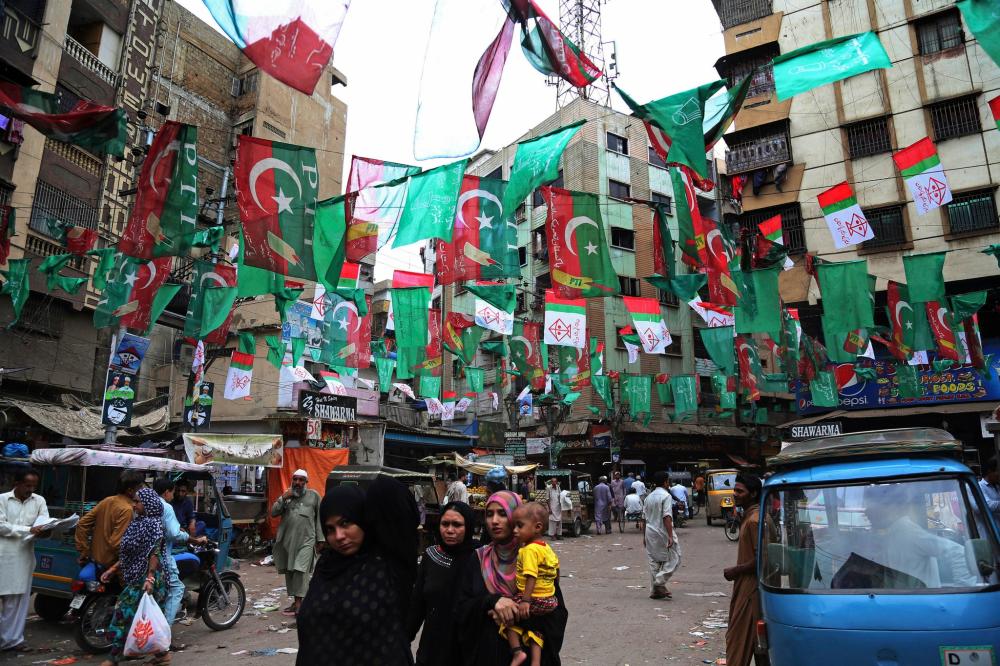 Banners and flags of different political parties in Karachi ahead of elections on Wednesday. — AP