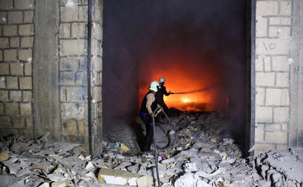 In this file photo taken on March 24, 2017, Syrian civil defense volunteers, known as the White Helmets, try to extinguish fire reportedly caused by air strikes in the northwestern city of Idlib. — AFP