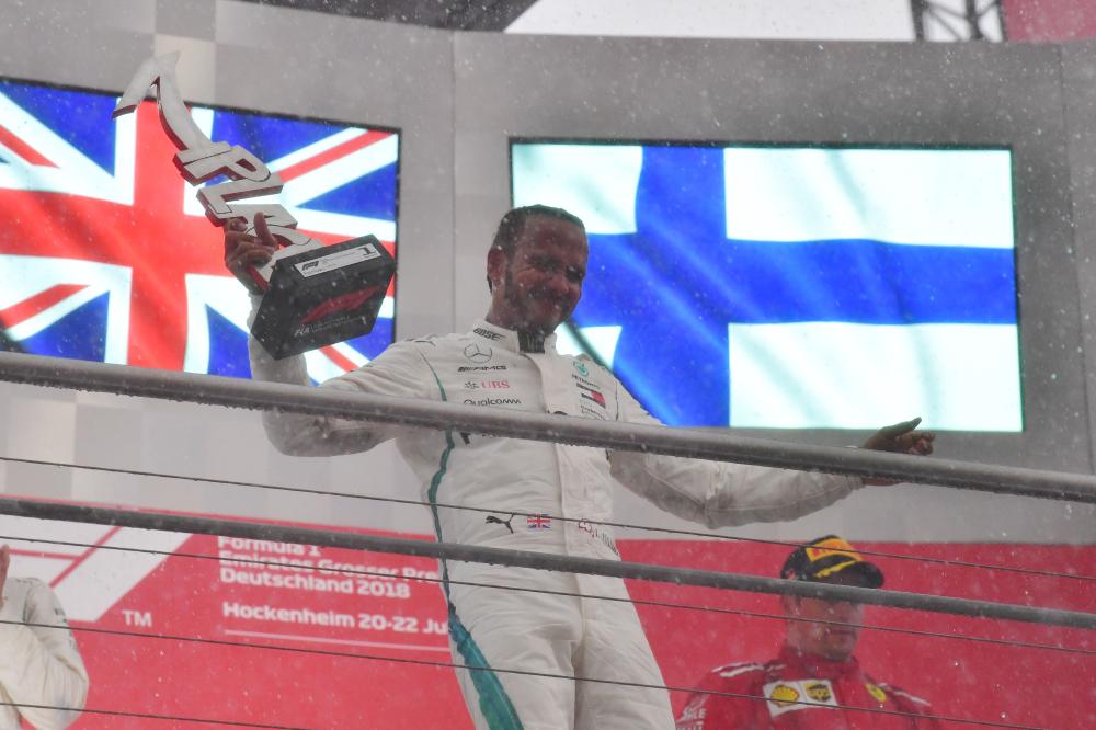 Mercedes' British driver Lewis Hamilton celebrates with the trophy after winning the German Formula One Grand Prix at the Hockenheim racing circuit in southern Germany Sunday. — AFP