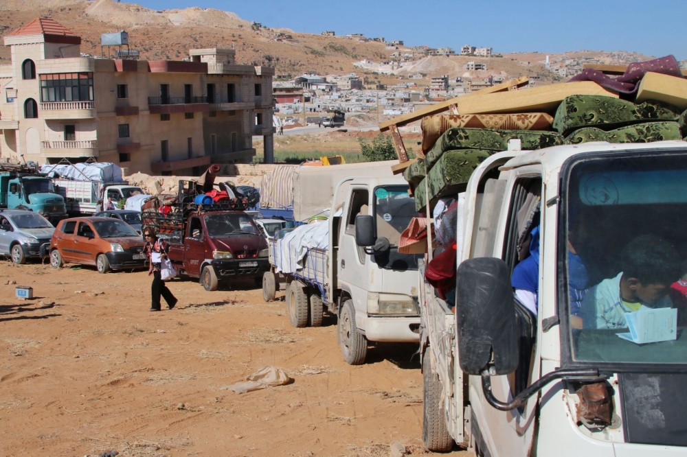 Syrian refugees form a convoy at a Lebanese army checkpoint in Wadi Hmeid in the Bekaa valley, after leaving the village of Arsal to return to their homes in Syria's Qalamoun region, Monday. — AFP