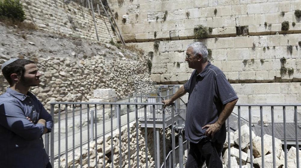 People stand near the part of the Western Wall where one of the stones dislodged and crashed into the prayer area in occupied Jerusalem, Monday. — Courtesy photo