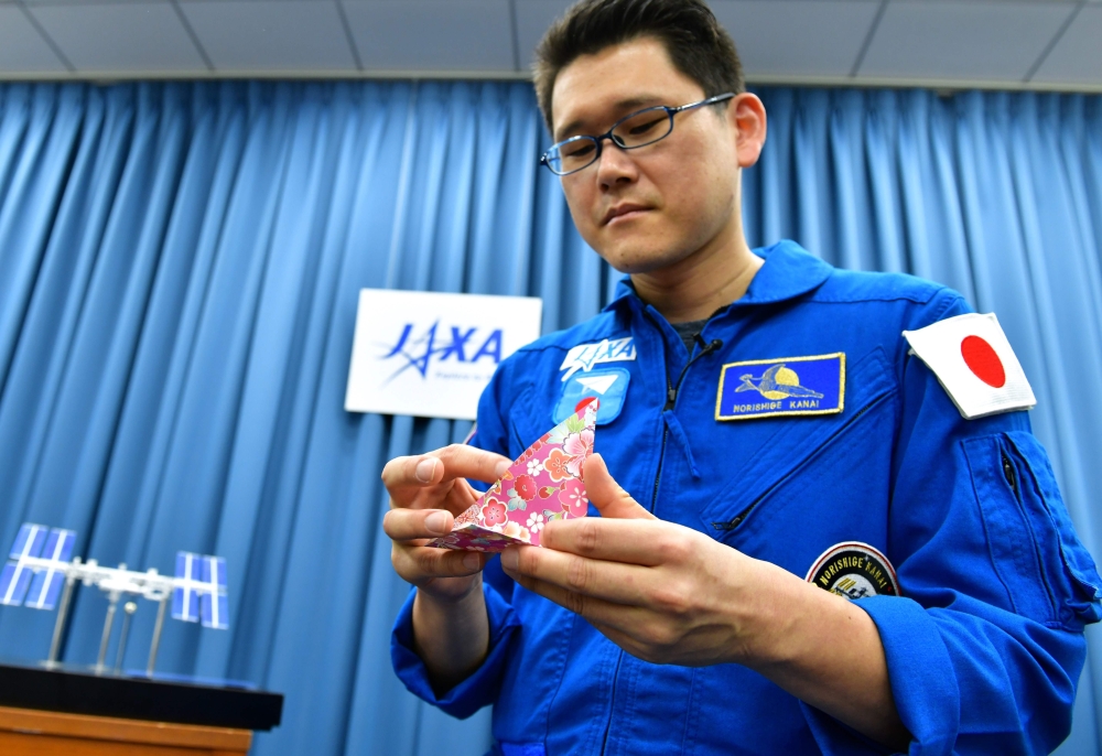 Japanese astronaut Norishige Kanai, a doctor and former diving medical officer in Japan’s Maritime Self-Defense Force, makes a paper crane during an interview in Tokyo on Friday. — AFP