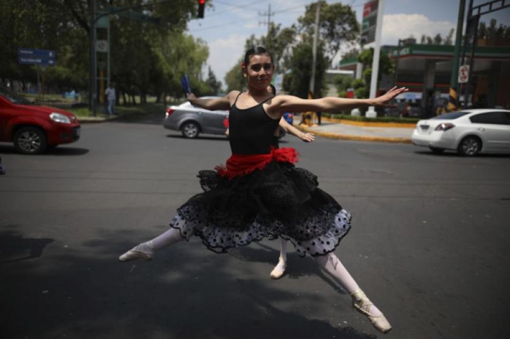 A ballerina dances at a traffic light stop in Mexico City on Saturday. - AP