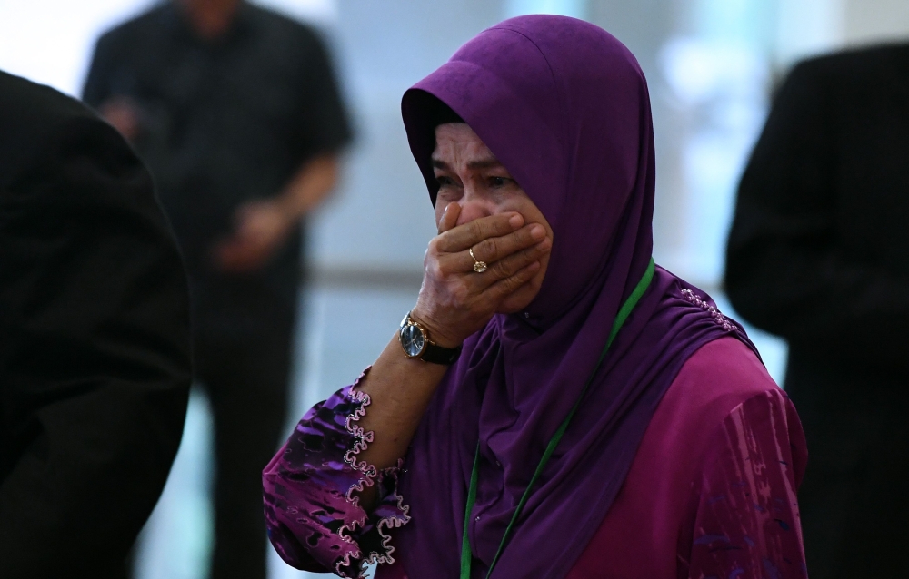 Sarah Nor, the mother of Norliakmar Hamid, a passenger on missing Malaysia Airlines flight MH370, cries as she arrives for the final investigation report on missing flight MH370 in Putrajaya, outside Kuala Lumpur, on Monday. — AFP