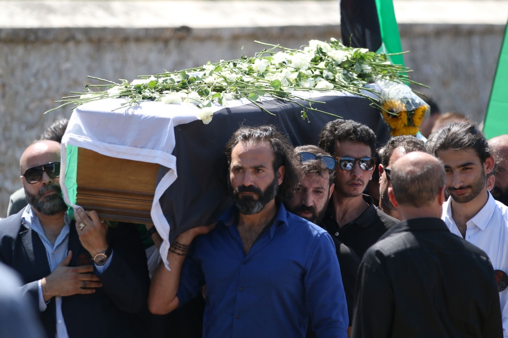Syrian actor Jala Al-Tawil, front, helps carry the coffin of Syrian actress and democracy activist exiled by the regime, Mai Skaf, along with her son Joud Al-Zobi, right, in Dourdan, a southwestern Paris suburb, on Friday. — AFP