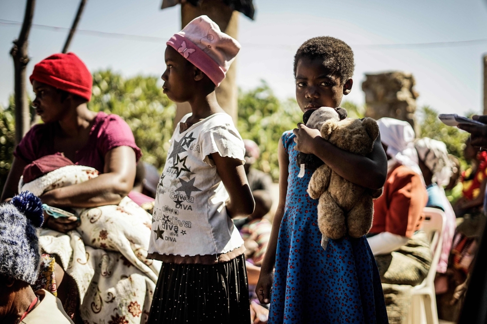 Children attend the funeral ceremony of Ishmael Kumire, 42, shot during post-election violence in Harare, at his homestead in Chinamhora village, Domboshava, outside Harare, Sunday. — AFP