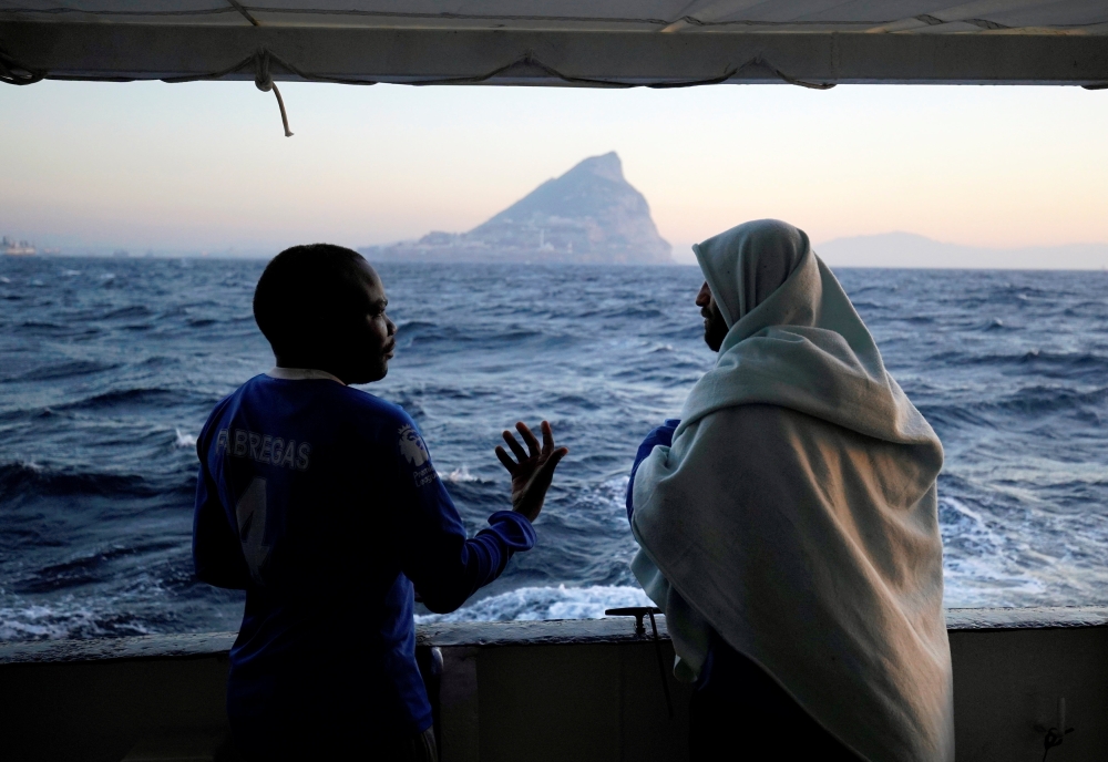 Migrants rescued by NGO Proactiva Open Arms rescue boat in central Mediterranean Sea stand on board before arriving at the port of Algeciras in San Roque, southern Spain, on Thursday. — AFP