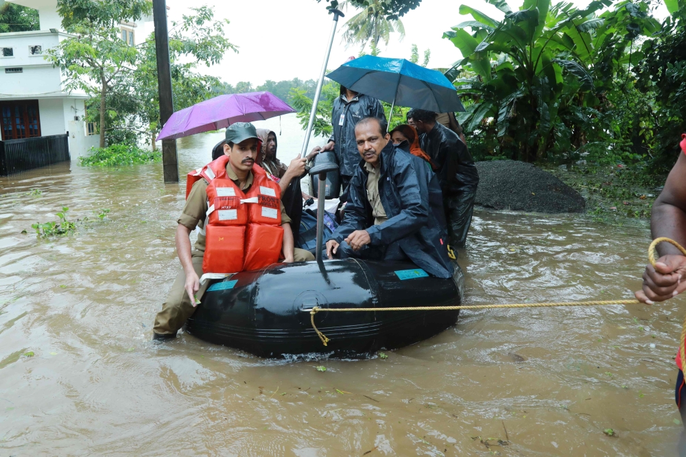 Fire and Rescue personnel evacuate local residents in an inflatable boat from a flooded area at Muppathadam near Eloor in Kochi’s Ernakulam district in the Indian state of Kerala on Wednesday. — AFP