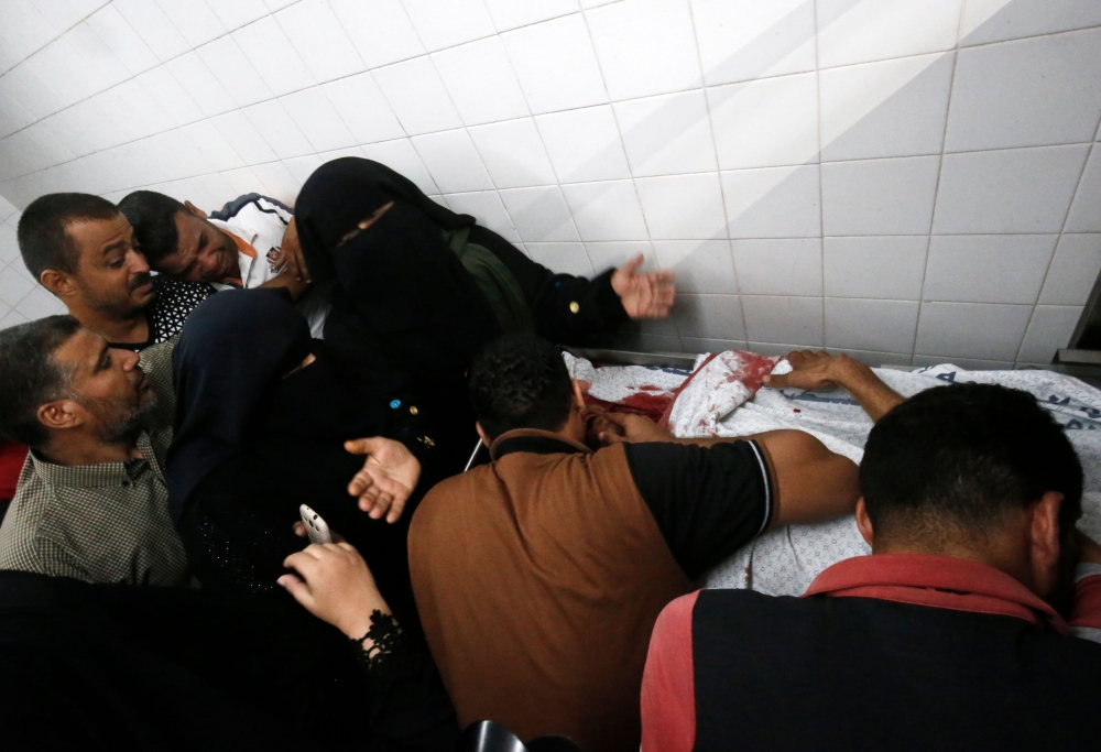 Relatives mourn over the body of Sadi Moamer, 26, who was killed during demonstrations near Rafah, at the morgue of a hospital near Rafah on Friday. — AFP