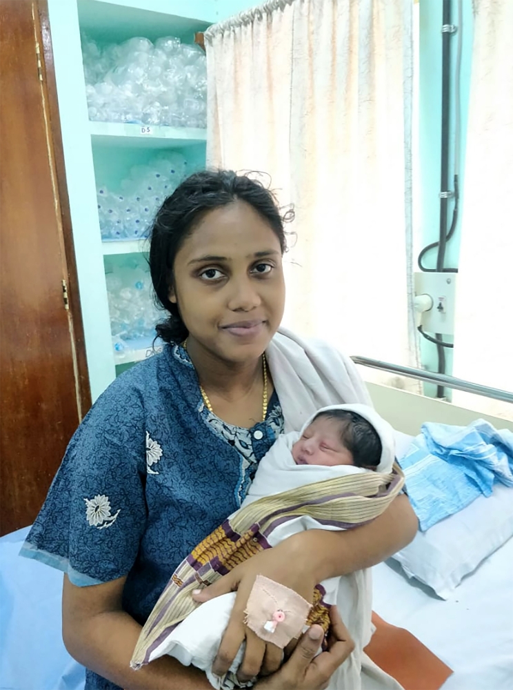 Sajita Jabeel, 25, is seen with her newborn boy in a hospital in Kochi, after she was rescued while heavily pregnant from a roof in a flood affected area of Kochi in the southern state of Kerala on Saturday. — AFP