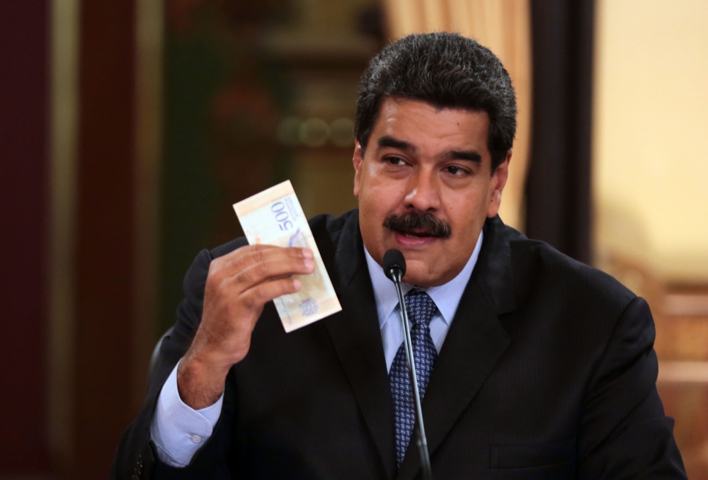 Handout picture released by the Venezuelan Presidency showing President Nicolas Maduro presenting fresh currency in the framework of new economic measures, during the broadcasting of a television programme at the Miraflores presidential palace in Caracas on Friday. — AFP