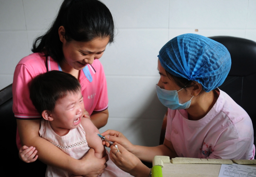 A child receives a vaccination shot at the local disease control and prevention center in Jiujiang in China’s central Jiangxi province in on Friday. — AFP