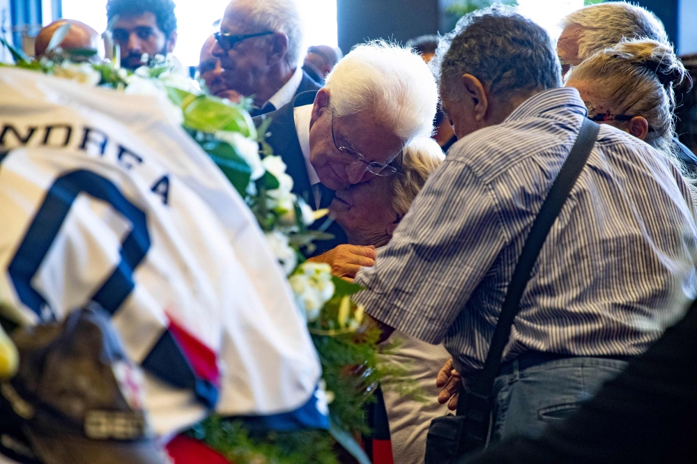 Italian President Sergio Mattarella, left, meets relatives of victims before attending the state funeral in Genoa, Italy, on Saturday. — AFP