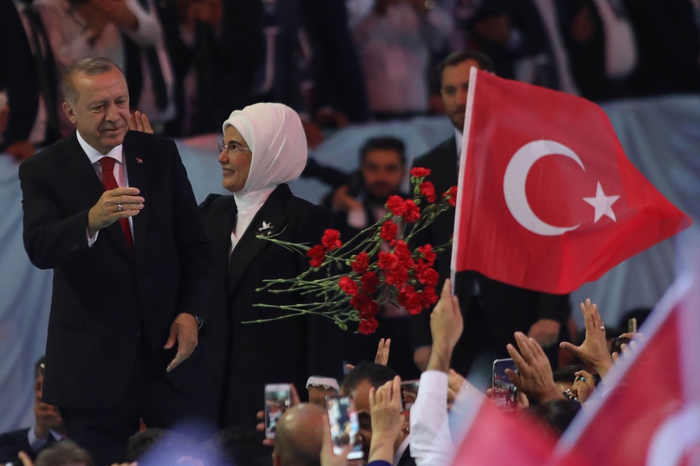 Turkish President Recep Tayyip Erdogan, left, and his wife Emine Erdogan, right, greet supporters of the ruling Justice and Development Party during party’s sixth congress to prepare for March local elections in Ankara on Saturday. — AFP