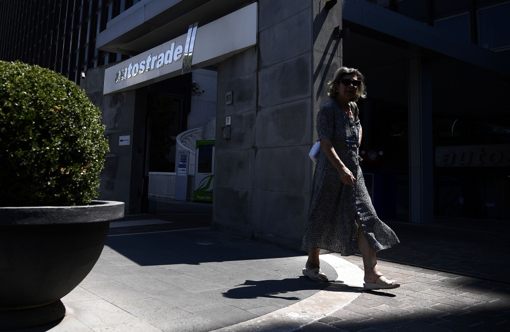 A woman walks in front of the headquarters with the logo of Italian infrastructure giant Autostrade per l’Italia, which operates and maintains nearly half Italy’s motorways, in Rome in this Aug. 16, 2018 file photo. — AFP
