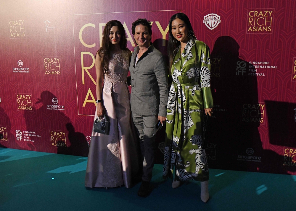 Producer John Penotti and guests pose at the film premiere of ‘Crazy Rich Asians’ at the Capitol Theatre in Singapore on Tuesday. — AFP