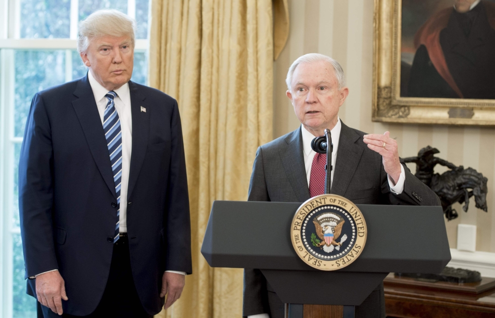 US President Donald Trump stands alongside US Attorney General Jeff Sessions after Sessions was sworn in, in the Oval Office of the White House in this Feb. 9, 2017 file photo. 