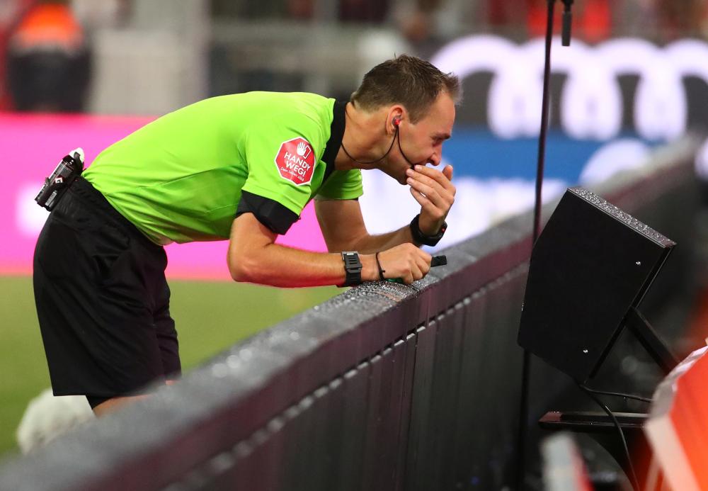 Referee Bastian Dankert checks VAR before disallowing a Bayern Munich goal for handball against TSG 1899 Hoffenheim at Allianz Arena, Munich, Friday. — Reuters