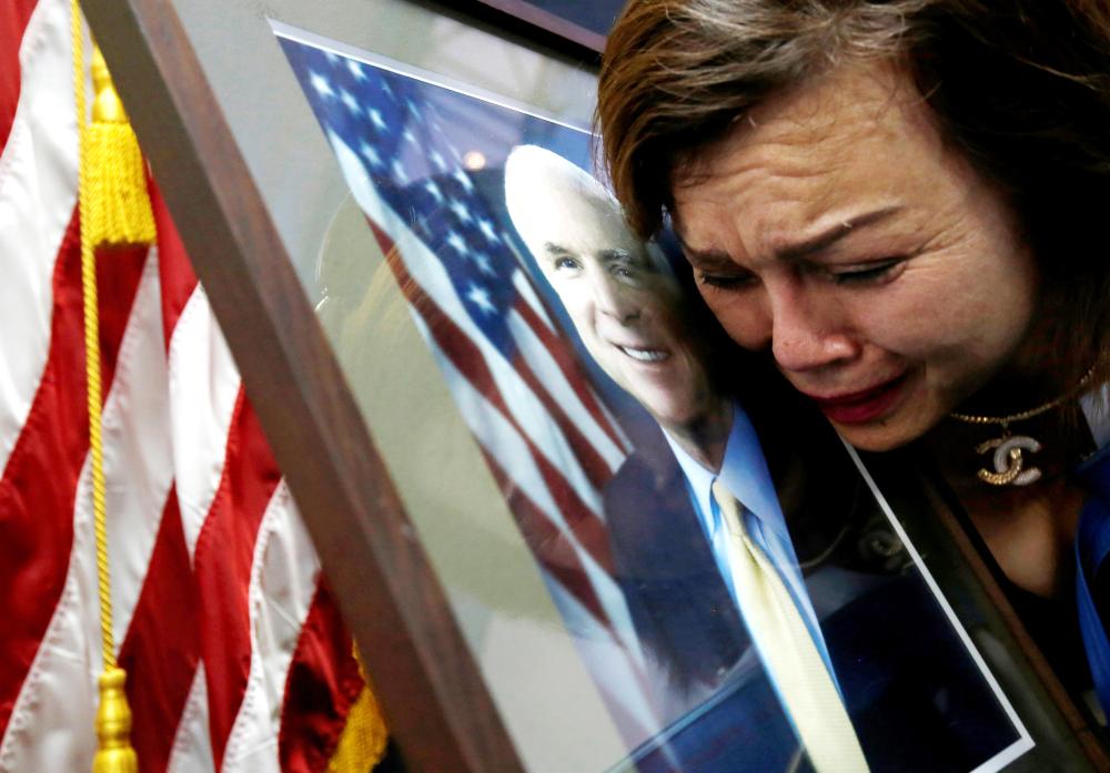 US Vietnam-born citizen Mai Tran mourns near a portrait of US Senator John McCain after she paid respect to him at the US embassy in Hanoi, Vietnam, on Monday. — Reuters