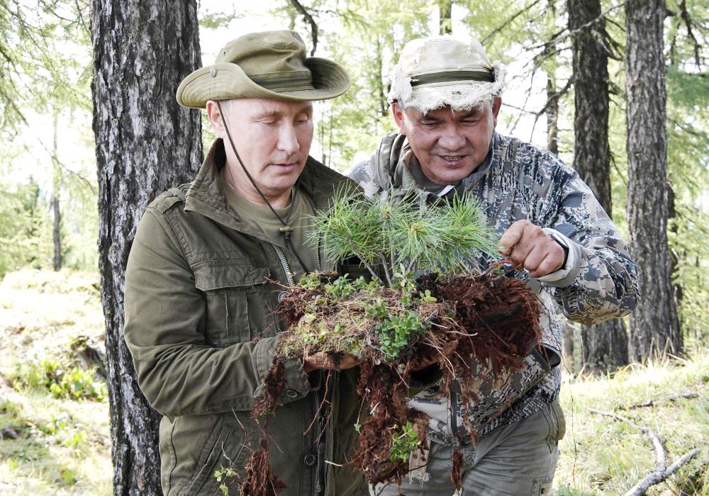 Russian President Vladimir Putin, left, and Russian Defense Minister Sergei Shoigu looking at vegetation during a short vacation in the remote Tuva region in southern Siberia on Sunday. — AFP