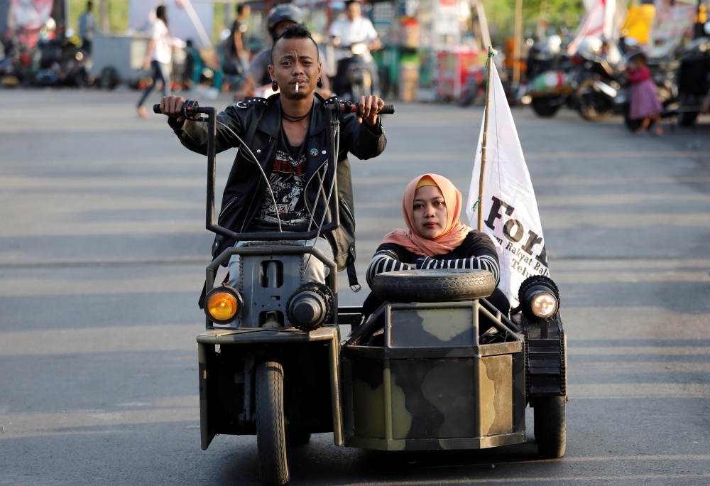 Extreme Vespa enthusiasts drive near the site of a scooter festival in Kediri, East Java, Indonesia. - Reuters
