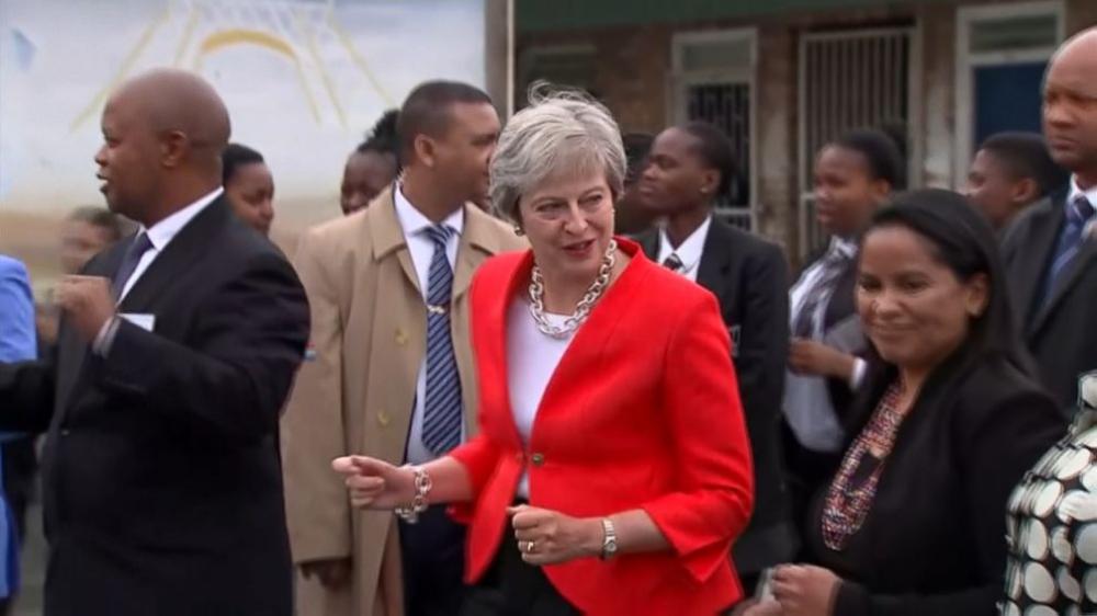 British Prime Minister Theresa May breaks out into a dance as she cheers on a group of schoolchildren performing a dance in Cape Town, South Africa on Tuesday. - AP