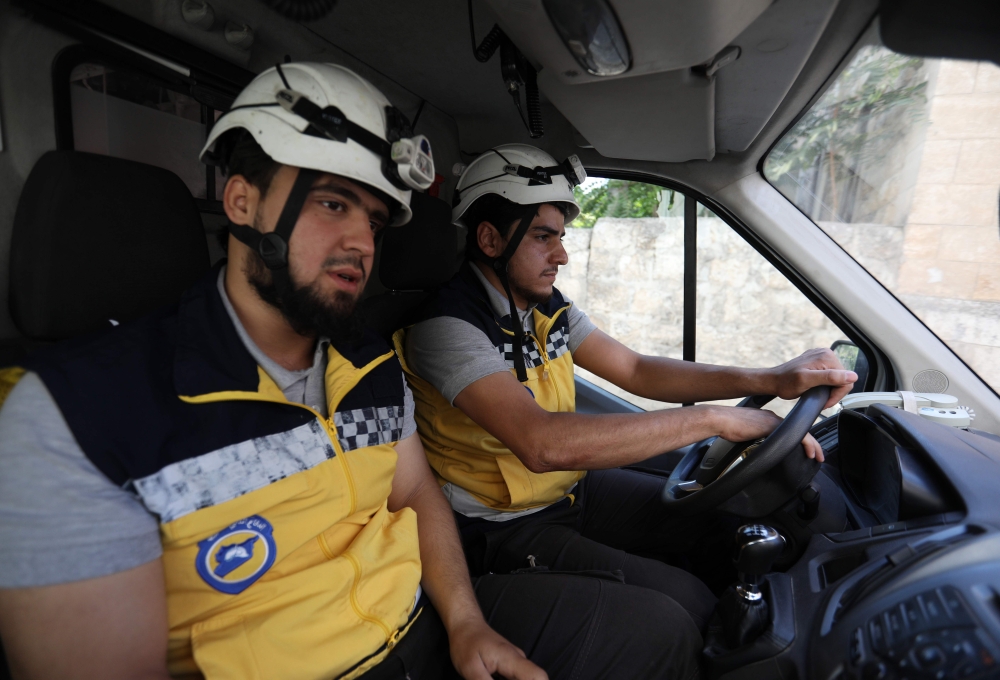 Members of a Syrian civil defense team known as The White Helmets sit in an ambulance after receiving an alert in the rebel-held northern Syrian city of Idlib on in this Aug. 26, 2018 file photo. — AFP