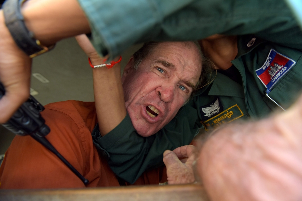 Australian filmmaker James Ricketson reacts as he attempts to speak to journalists from a prison vehicle after his verdict at the Phnom Penh court on Friday. — AFP