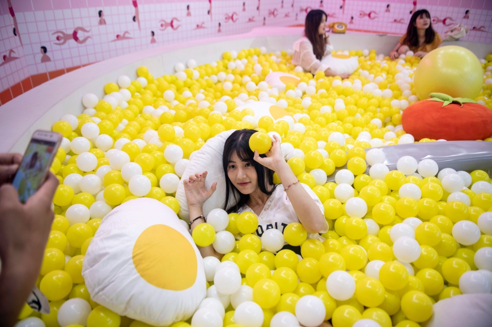 Visitors pose for photographs at The Egg House in Shanghai, China on Saturday. The Egg House is where an apparently unhealthy interest in eggs and selfies meets 