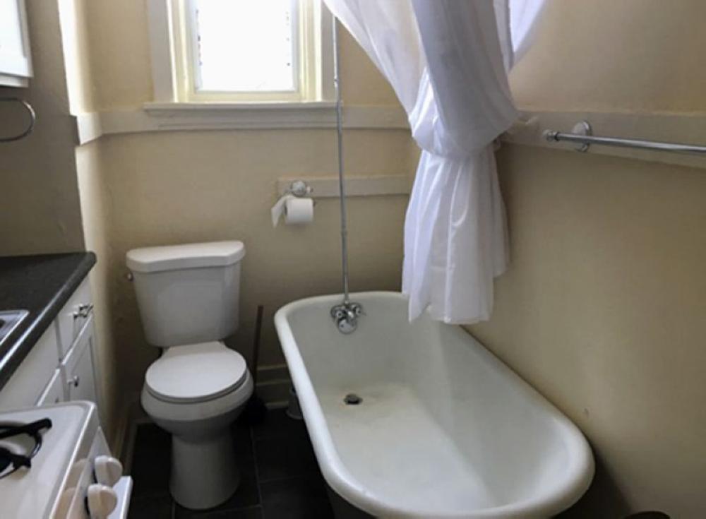 This photo from a rental ad provided by S.F. Shannon Real Estate Management LLC shows a toilet and bathtub in the kitchen of an apartment in St. Louis, Missouri. - AP