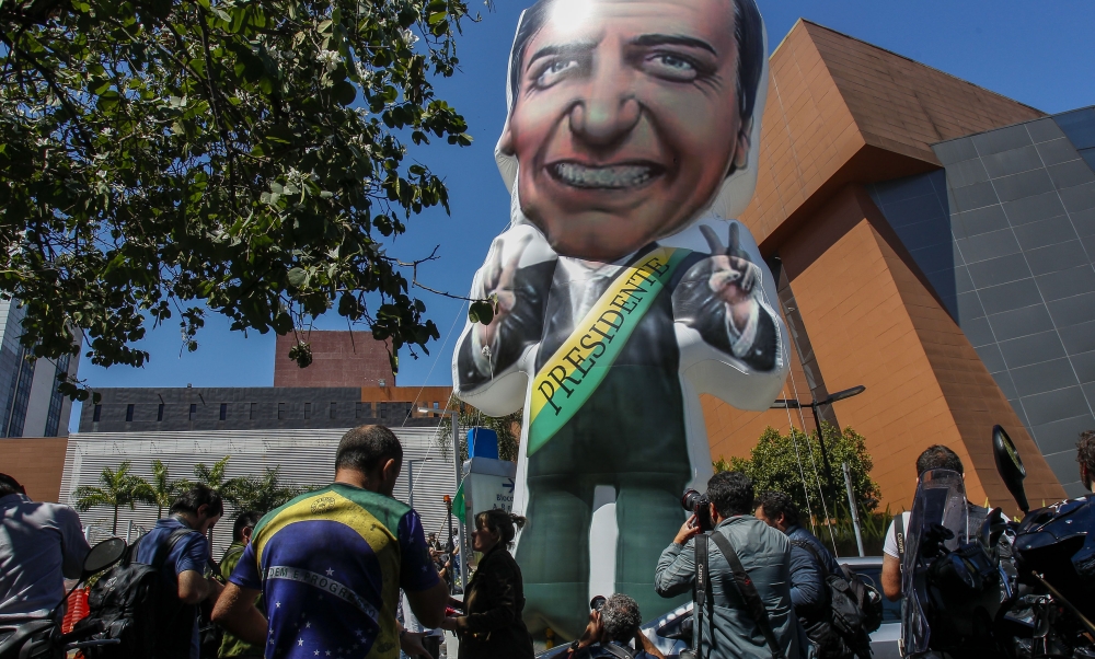 A balloon depicting Brazilian right-wing presidential candidate Jair Bolsonaro is seen next to journalists outside the Albert Einstein Hospital in Sao Paulo, Brazil, on Friday. — AFP