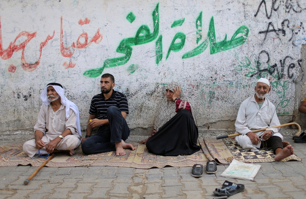 Palestinians sit outside their houses at Khan Younis refugee camp in the southern Gaza Strip in this Sept. 10, 2018 file photo. — Reuters
