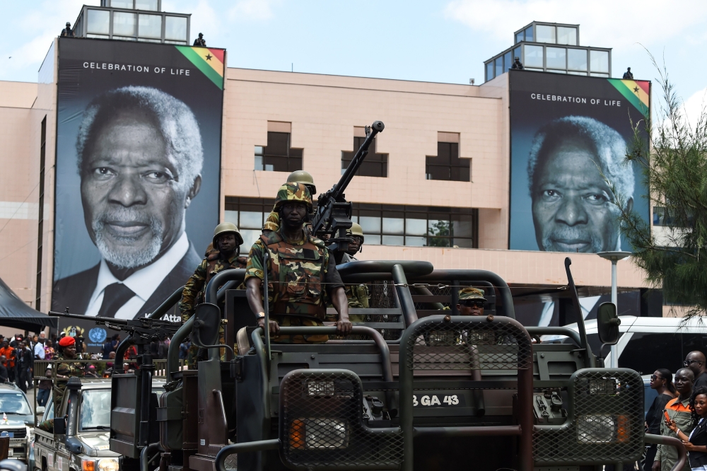 Soldiers stand in a military vehicle as they lead the procession to the cemetery for the burial of Kofi Annan in front of the Accra International Conference Centre on Thursday. — AFP