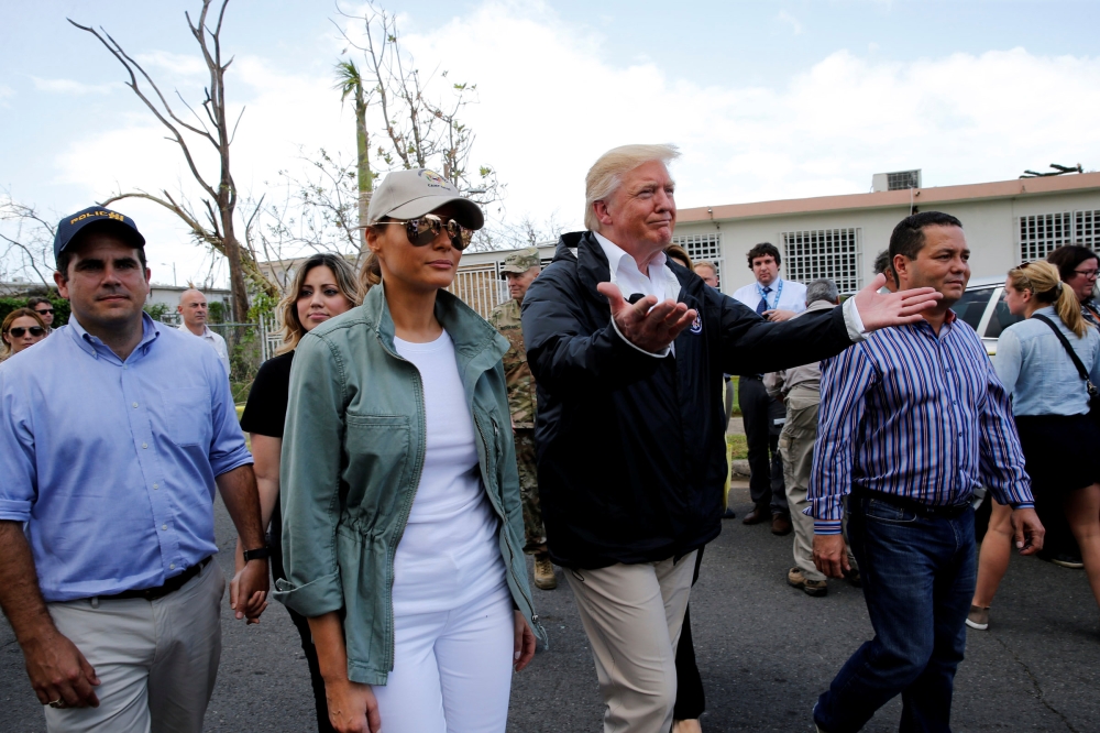 US President Donald Trump and first lady Melania Trump walk through a neighborhood damaged by Hurricane Maria in Guaynabo, Puerto Rico, in this Oct, 3, 2017 file photo. — Reuters