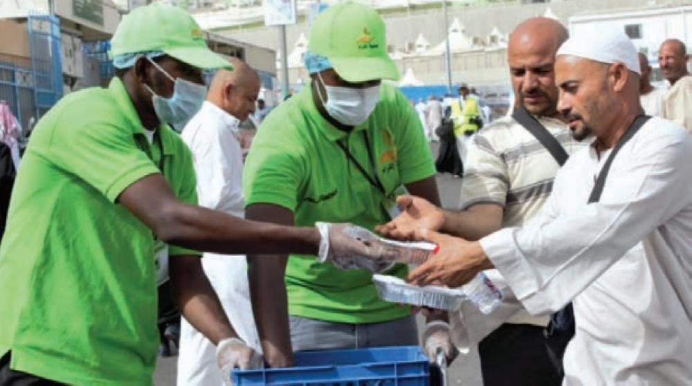 Volunteers from charitable organizations distribute meals among the needy in Makkah during the Haj season.