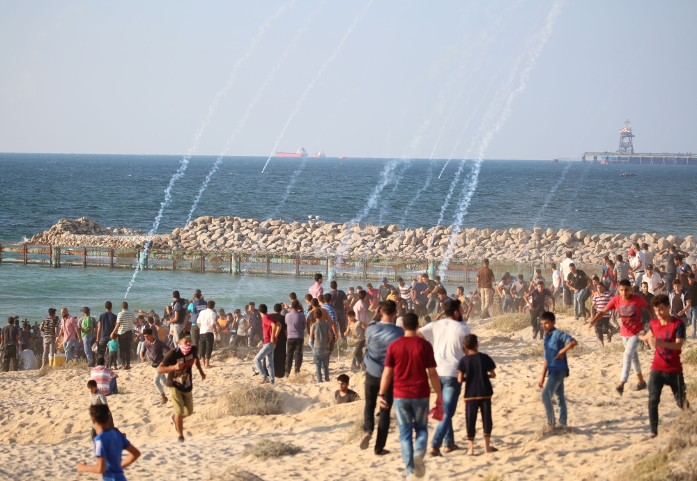 Tear gas is fired on Palestinian demonstrators during a protest calling for lifting of the Israeli blockade on Gaza, on a beach in Beit Lahia near the maritime border with Israel, Monday. — AFP
