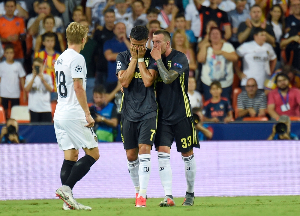 Juventus' Portuguese forward Cristiano Ronaldo (C) reacts after receiving a red card during the UEFA Champions League Group H football match against Valencia CF at the Mestalla stadium in Valencia on Wednesday. — AFP