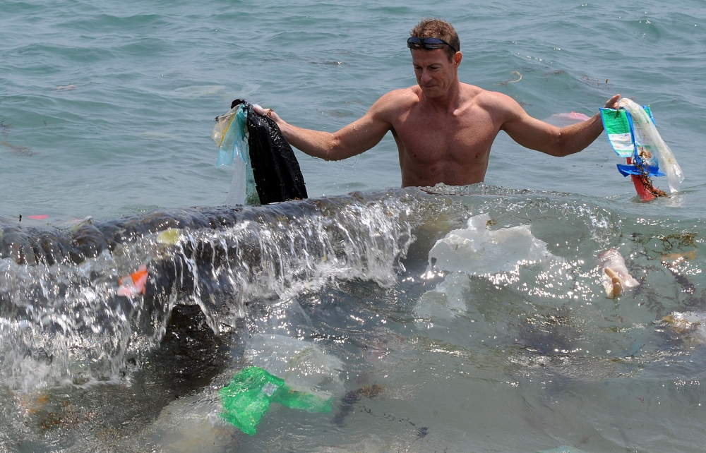 In this file photo, Doug Woodring, an entrepreneur and conservationist who lives in Hong Kong, displays rubbish on a beach on the south side of Hong Kong. Coca-Cola, Walmart and other big multinationals pledged on Friday, to help reduce plastic pollution in the world's oceans in support of a campaign by five of the G7 industrialized nations. Britain, Canada, France, Germany and Italy, along with the European Union, signed the Ocean Plastics Charter at a leaders summit in Canada's Charlevoix region in June.  — AFP